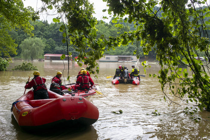 Water rescue teams travel overflowed Troublesome Creek on Friday to rescue people that have been stranded since Wednesday night in Lost Creek, Ky.