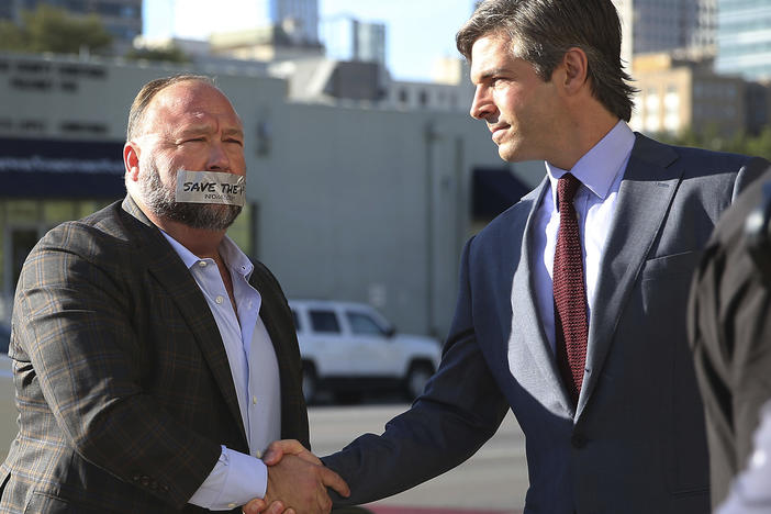 Alex Jones arrives at the Travis County Courthouse in Austin, Texas, on July 26, 2022, with a piece of tape over his mouth that reads "save the 1st."