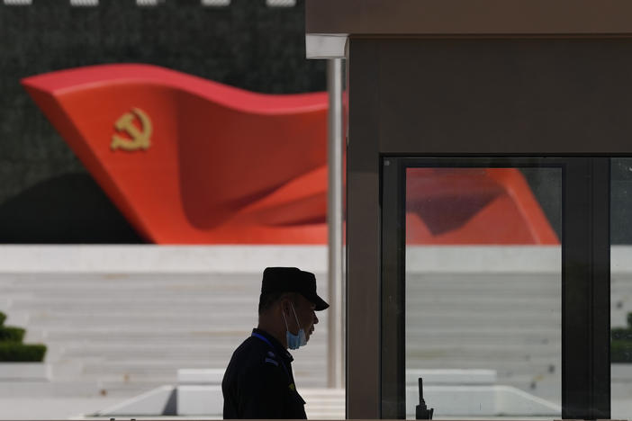 A security guard stands near a sculpture of the Chinese Communist Party flag at the Museum of the Communist Party of China on May 26, 2022, in Beijing. China said it was conducting military exercises Saturday, off its coast opposite Taiwan.
