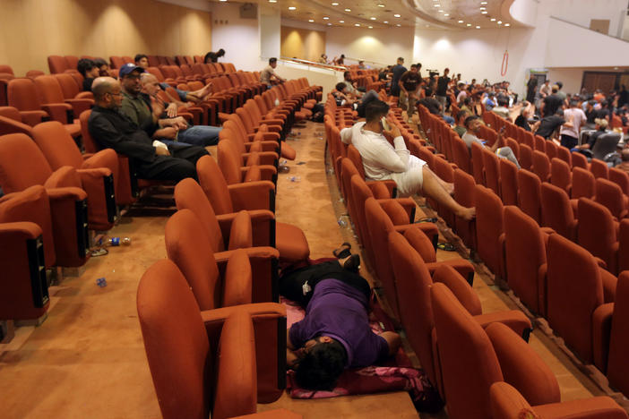 Iraqi protesters rest inside the Parliament building in Baghdad on Sunday. Thousands of followers of an influential Shiite cleric stormed into the building on Saturday, for the second time this week, protesting government formation efforts led by his rivals, an alliance of Iran-backed groups.