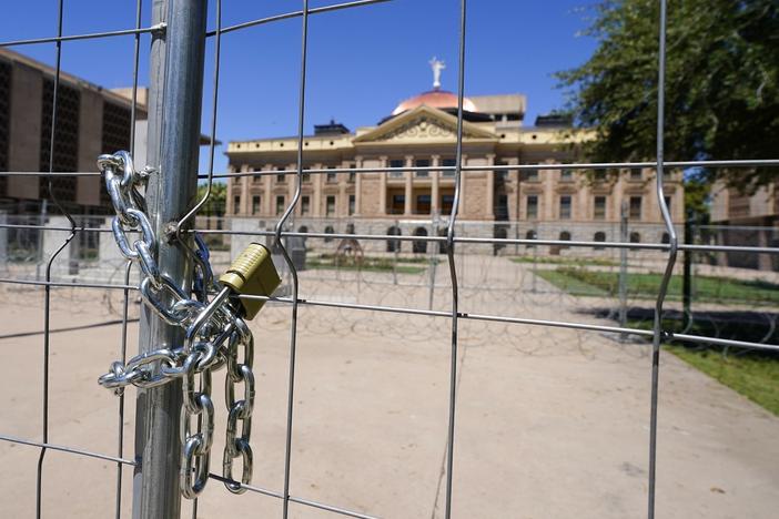 After multiple nights of abortion-rights protests, security fences and barbed wire surround the Arizona Capitol, Monday, June 27, 2022, in Phoenix.