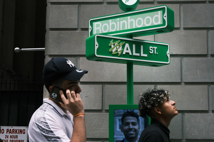 People wait in line for T-shirts at a pop-up kiosk for the online brokerage Robinhood in New York City after the company went public on July 29, 2021. On Tuesday, the company said it was cutting nearly a quarter of its staff.