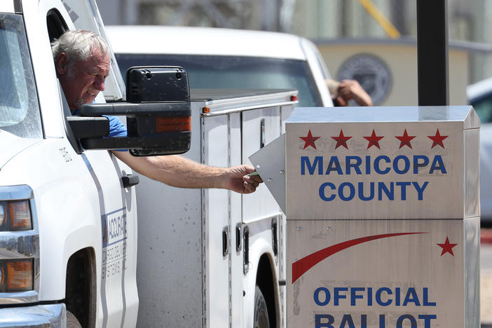 A voter places a ballot in a drop box outside of the Maricopa County Elections Department on August 02, 2022 in Phoenix, Arizona. Arizonans are voting in the state's midterm primary election.