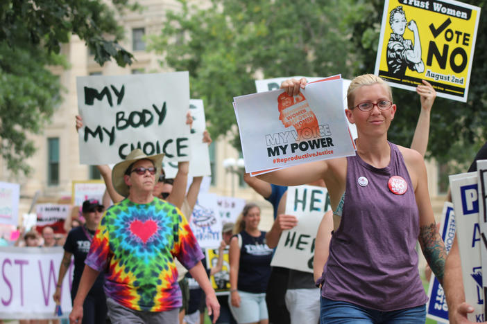 Protesters who oppose a state constitutional amendment that would remove the right to abortion in Kansas march around the Kansas Statehouse in Topeka.