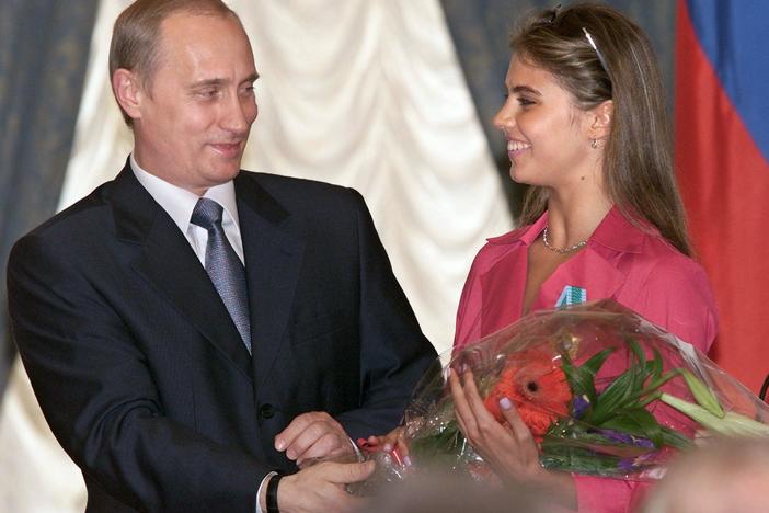 Russian President Vladimir Putin hands flowers to Alina Kabaeva after awarding her with an Order of Friendship during a ceremony at the Kremlin in June 2001.