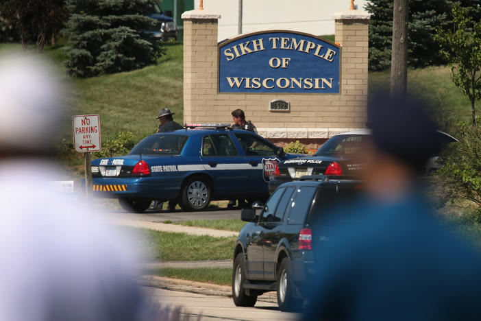 Police guard the front of the Sikh Temple of Wisconsin where at least one gunman fired upon people at a service August, 5, 2012 in Oak Creek, Wis. Six people were killed when a shooter, who was later shot dead by a police officer, opened fire on congregants in the Milwaukee suburb.