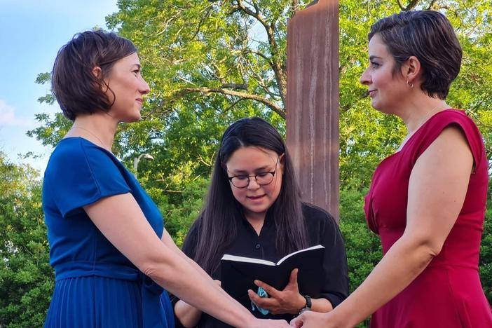 Carlie Brown (left) and Molly Pela exchange wedding vows as their friend, Julie Takahashi, officiates the ceremony. Both women said they rushed to get married after reading Supreme Court Justice Clarence Thomas' concurring opinion in striking down <em>Roe v. Wade</em>, in which he suggested also overturning the landmark case that legalized same-sex marriage.