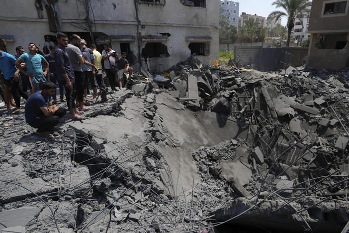 Gaza residents on Saturday inspect the rubble of a destroyed residential building hit by Israeli airstrikes.