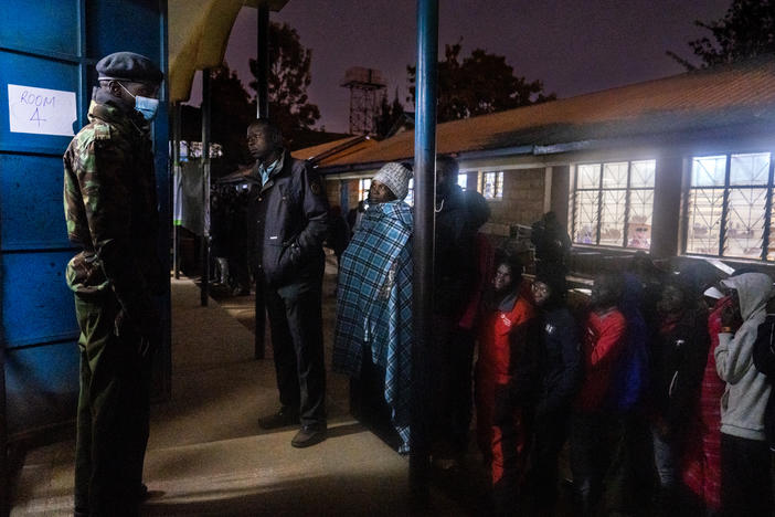 The first voters in the Kibera slum in Nairobi, Kenya, look into one of the many polling rooms at Olympic Primary just minutes before voting commences on Tuesday.