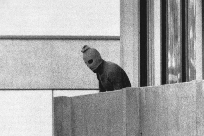 A member of Black September appears on the balcony of the apartment where gunmen held members of the Israeli Olympic team hostage on Sept. 5, 1972. It was the first time a terrorist attack had been broadcast live to a global audience.