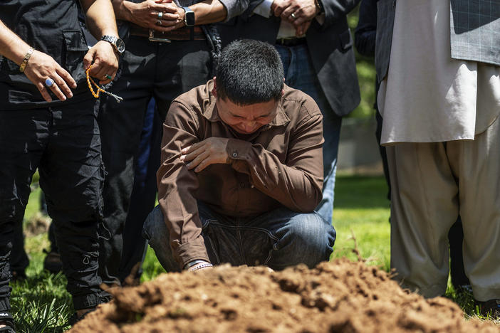 Altaf Hussain cries over the grave of his brother Aftab Hussein at Fairview Memorial Park in Albuquerque, N.M., on Friday, Aug. 5, 2022. A funeral service was held for Aftab Hussein, 41, and Muhammad Afzaal Hussain, 27, at the Islamic Center of New Mexico on Friday.