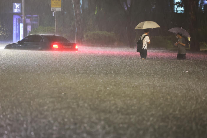 A vehicle is submerged in a flooded road in Seoul, Monday, Aug. 8, 2022.