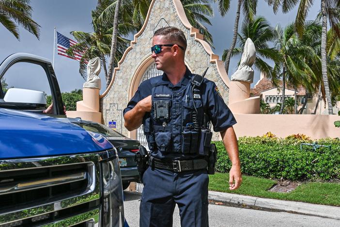Local law enforcement officers are seen in front of the home of former President Donald Trump at Mar-a-Lago in Palm Beach, Fla., on Tuesday.