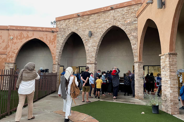Participants in an interfaith memorial ceremony enter the New Mexico Islamic Center mosque to commemorate four murdered Muslim men, hours after police said they had arrested a prime suspect in the killings, in Albuquerque, N.M., on Tuesday.
