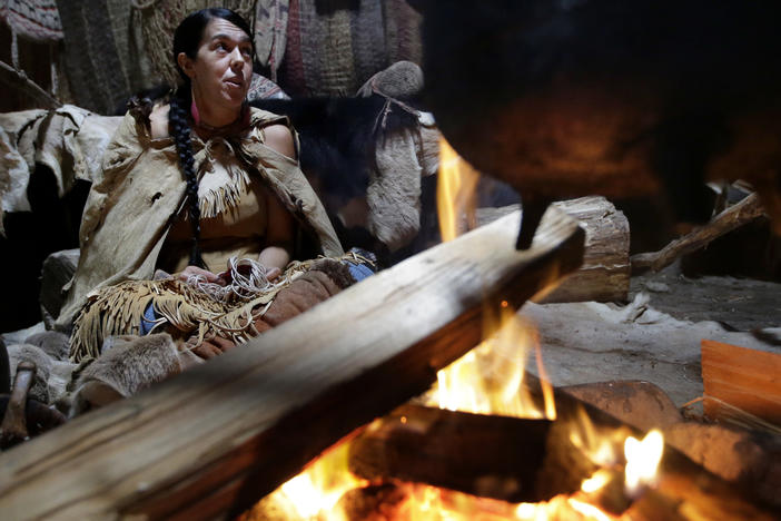 Mashpee Wampanoag Kerri Helme uses plant fiber to weave a basket while sitting next to a fire on November 15, 2018, at the Wampanoag Homesite at the Plimoth Patuxet Museums, in Plymouth, Mass.