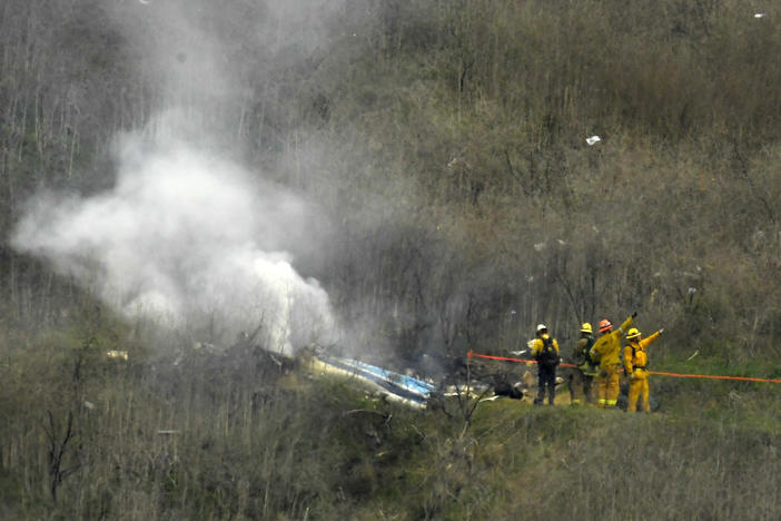 Firefighters work the scene of a helicopter crash where former NBA basketball star Kobe Bryant died in Calabasas, Calif., on Jan. 26, 2020. Bryant's widow is taking her lawsuit against the Los Angeles County Sheriff's Department and Fire Department to a federal jury seeking compensation for photos deputies shared of the remains of the NBA star, his daughter and seven others who died in the crash.