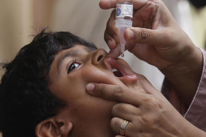 A health worker gives a polio vaccine to a child in Karachi, Pakistan, on May 23. British health authorities on Wednesday said they will offer a polio booster dose to children aged 1 to 9 in London, after finding evidence the virus has been spreading in multiple regions of the capital.