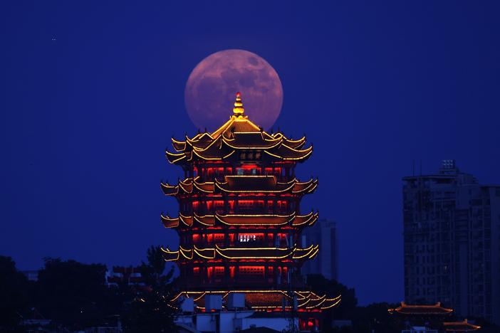 A supermoon is pictured near the Yellow Crane Tower in Wuhan, central China's Hubei Province, July 13, 2022.