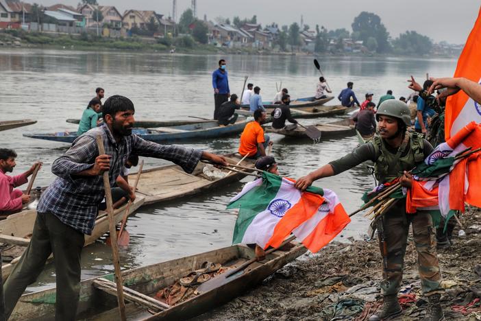 An Indian army soldier collects Indian national flags after a rally marking Indian independence in Sopore district, Baramulla, in Jammu and Kashmir, on Aug. 11.
