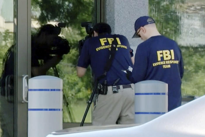 FBI agents document evidence outside a bureau field office in Kenwood, Ohio, on Aug. 11, after an armed man tried to breach the building. He fled and was later killed by law enforcement, authorities said.