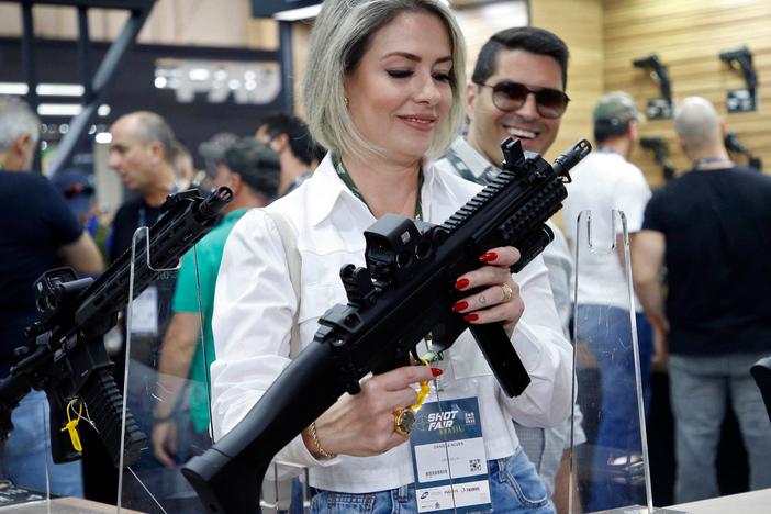 A visitor holds a weapon during the Shot Fair Brasil, an arms exhibition held at the Expoville Conventions and Exhibitions Center in Joinville, Santa Catarina state, Brazil, on Aug. 5.