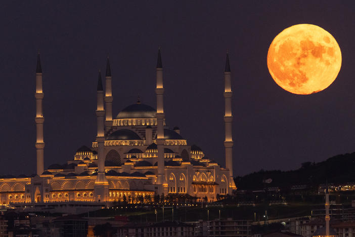 Istanbul, Turkey: The Sturgeon full moon rises next to Istanbul's Camlica Mosque.