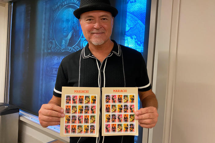 Rafael López poses with his mariachi stamps in a classroom at the Smithsonian's National Postal Museum. The set was launched in August.