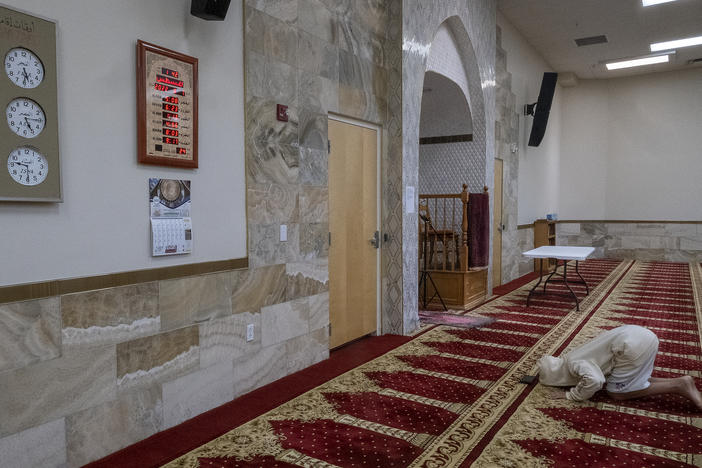 A young unidentified man bows during the Dhuhr afternoon prayer at the Islamic Center of New Mexico on Aug. 7, 2022, after the fourth Muslim man was killed in Albuquerque.