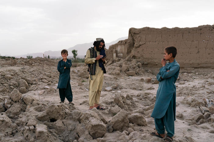 Wahadat (center) stands in the ruins of the village of Mali Khel.