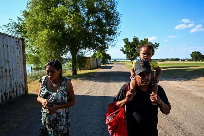 A migrant family is apprehended by U.S. Border Patrol agents and National Guard troops in Eagle Pass, Texas, near the border with Mexico on June 30, 2022.