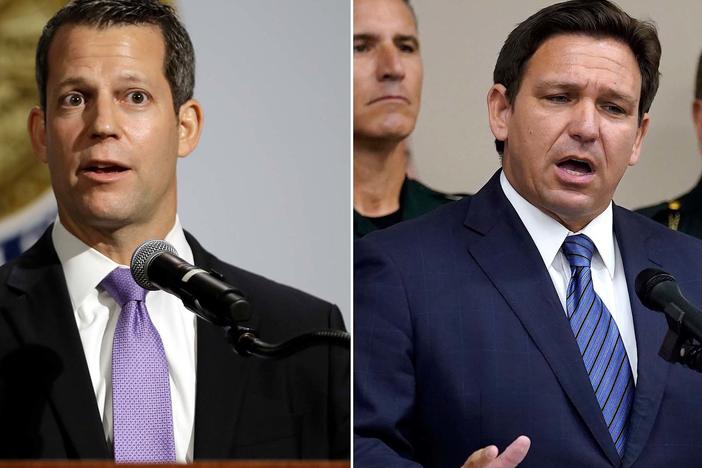 Florida Gov. Ron DeSantis, right, and Hillsborough County State Attorney Andrew Warren, left, in Tampa, Fla., after DeSantis suspended Warren. Warren vowed to fight his suspension over his promise not to enforce the state's 15-week abortion ban and support for gender transition treatments for minors.