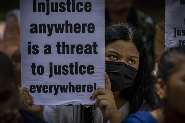 An activist holds a placard during a protest against remission of sentence by the government to convicts of a gang rape, in New Delhi, India, Thursday, Aug. 18, 2022.