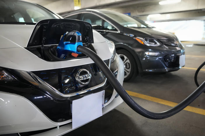 Electric vehicles are displayed at a news conference with White House Climate Adviser Gina McCarthy and Secretary of Transportation Pete Buttigieg in Washington, D.C., on April 22, 2021. The Biden administration's climate and health care bill passed by Congress last week revamps a tax credit for buyers of electric cars.