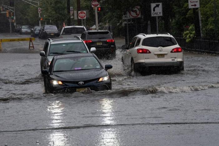 Cars drive on flooded streets as Tropical Storm Henri approaches, in Hoboken New Jersey on August 22, 2021.