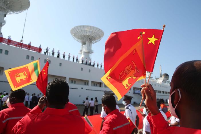 People welcoming China's ship Yuan Wang 5 wave Chinese and Sri Lankan flags at Sri Lanka's Hambantota International Port in Sri Lanka, Aug. 16.