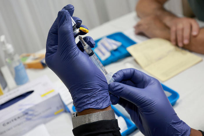 A health-care worker prepares to administer a free monkeypox vaccine in Wilton Manors, Florida. The question: Can vaccination slow the outbreak?