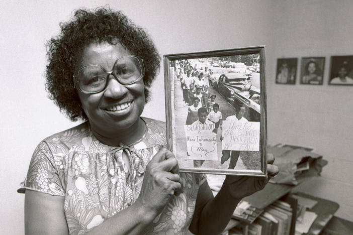 Civil rights leader Clara Luper poses with a photograph from her scrapbooks at a community center in Oklahoma City, Okla., in August 1983.