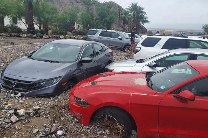 In this photo provided by the National Park Service, cars are stuck in mud and debris from flash flooding at The Inn at Death Valley in Death Valley National Park on Aug. 5, 2022.