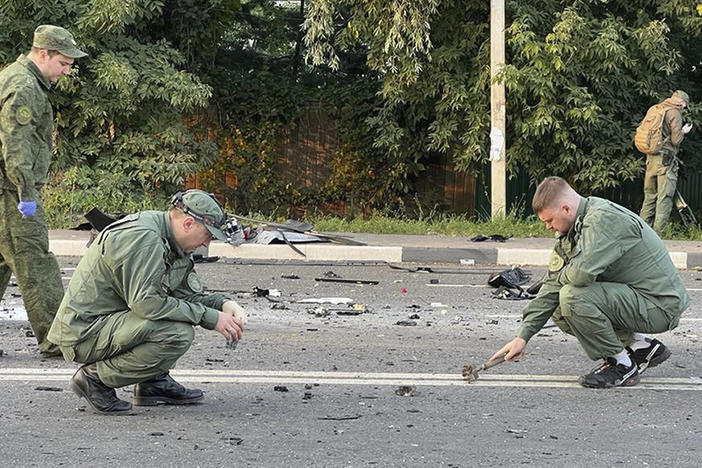 Investigators work at the site of a car explosion that killed Daria Dugina outside Moscow. She was the daughter of a key Putin ally.
