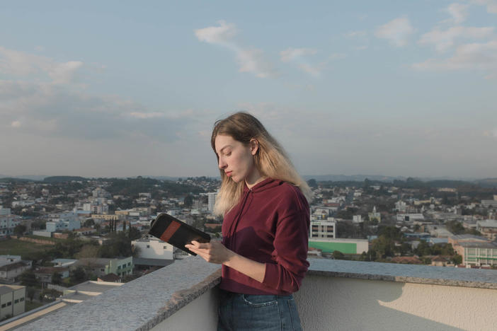 Ukrainian refugee Anastasiia Ivanova reads the Bible on the terrace of the apartment in Prudentópolis, Brazil, where she now lives with her mother and siblings. The devout 22-year-old says her faith is what's helped her get through all of her trials. She brought her Bible with her when the family fled Kharkiv.