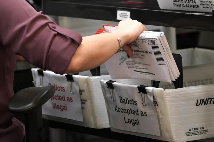 In this 2020 photo, an election worker sorts vote-by-mail ballots at the Miami-Dade County Board of Elections in Doral, Fla.