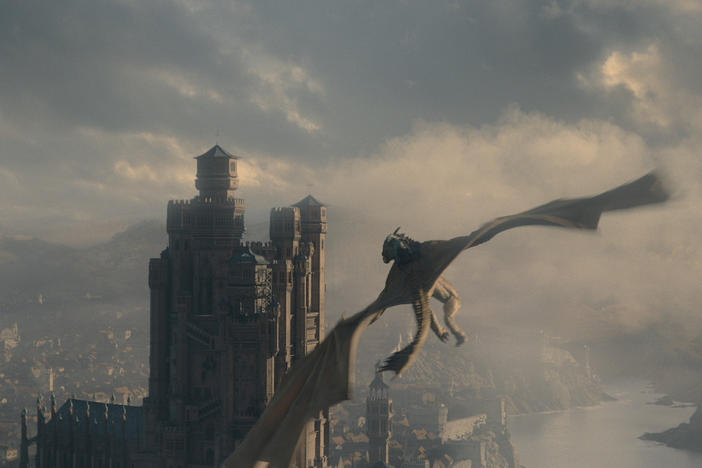 A dragon flies over King's Landing on <em>House of the Dragon</em>.