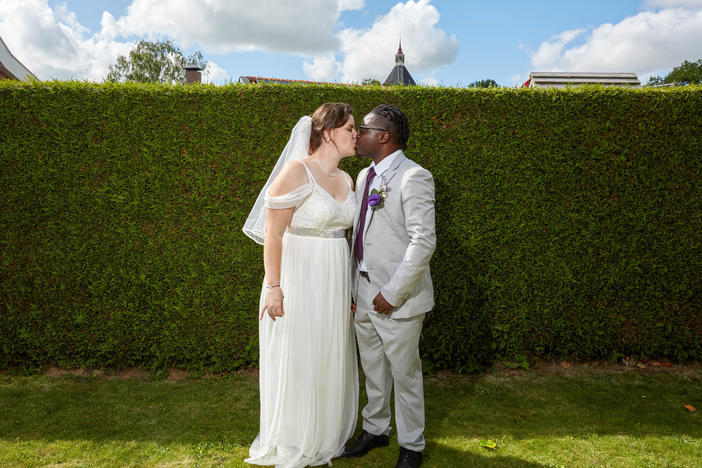 Fiona ten Have and Patrick Phiri pose for a wedding portrait in front of the same hedge where NPR photographed them during his first visit to the Netherlands (see photo, below).