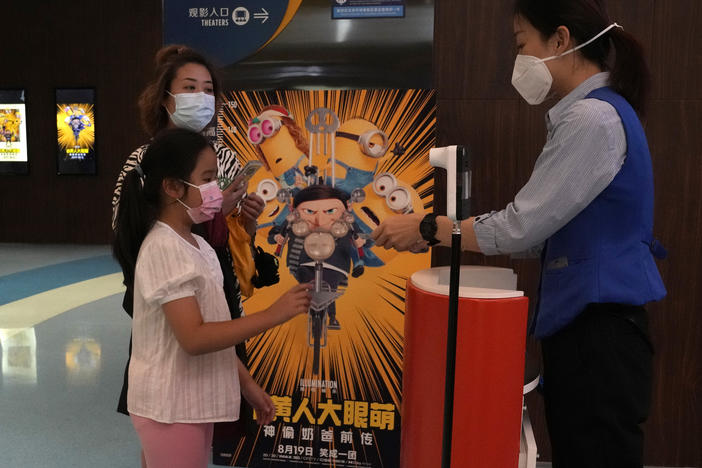 Visitors to a cinema showing the latest "Minions: The Rise of Gru" movie get their tickets checked in Beijing.