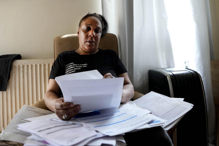 Jennifer Jones sorts her bills at her small flat in London, Thursday, Aug. 25, 2022. Like millions of people, Jones, 54, is struggling to cope as energy and food prices skyrocket during Britain's worst cost-of-living crisis in a generation.