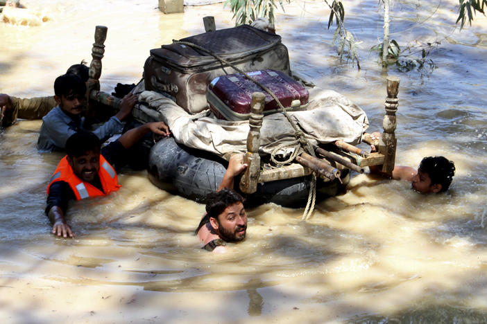 Displaced people float belongings salvaged from flood-hit homes on the outskirts of Peshawar, Pakistan, on Sunday.