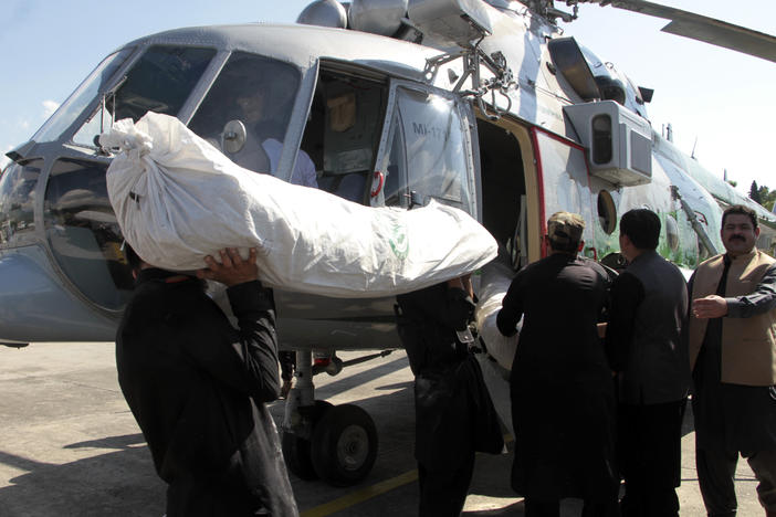 Tents for flood-affected people are loaded to a helicopter by frontier constabularies, in Swat valley, Pakistan, Sunday, Aug. 28, 2022.