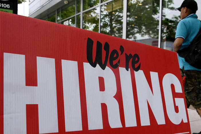 A man walks past a "now hiring" sign posted outside of a restaurant in Arlington, Va., on June 3.