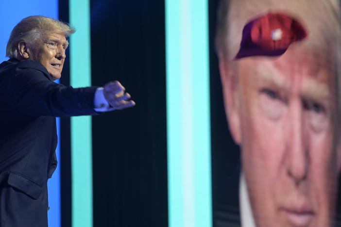Former President Donald Trump tosses hats into the crowd before addressing attendees during the Turning Point USA Student Action Summit on July 23, 2022, in Tampa, Fla.
