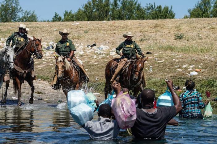The woman identified in court papers as Esther (far right) was among Haitian migrants who say they were threatened by Border Patrol agents on horseback last September as they tried to return to a makeshift camp in Del Rio, Texas.